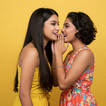 A girl whispering in another girl ears