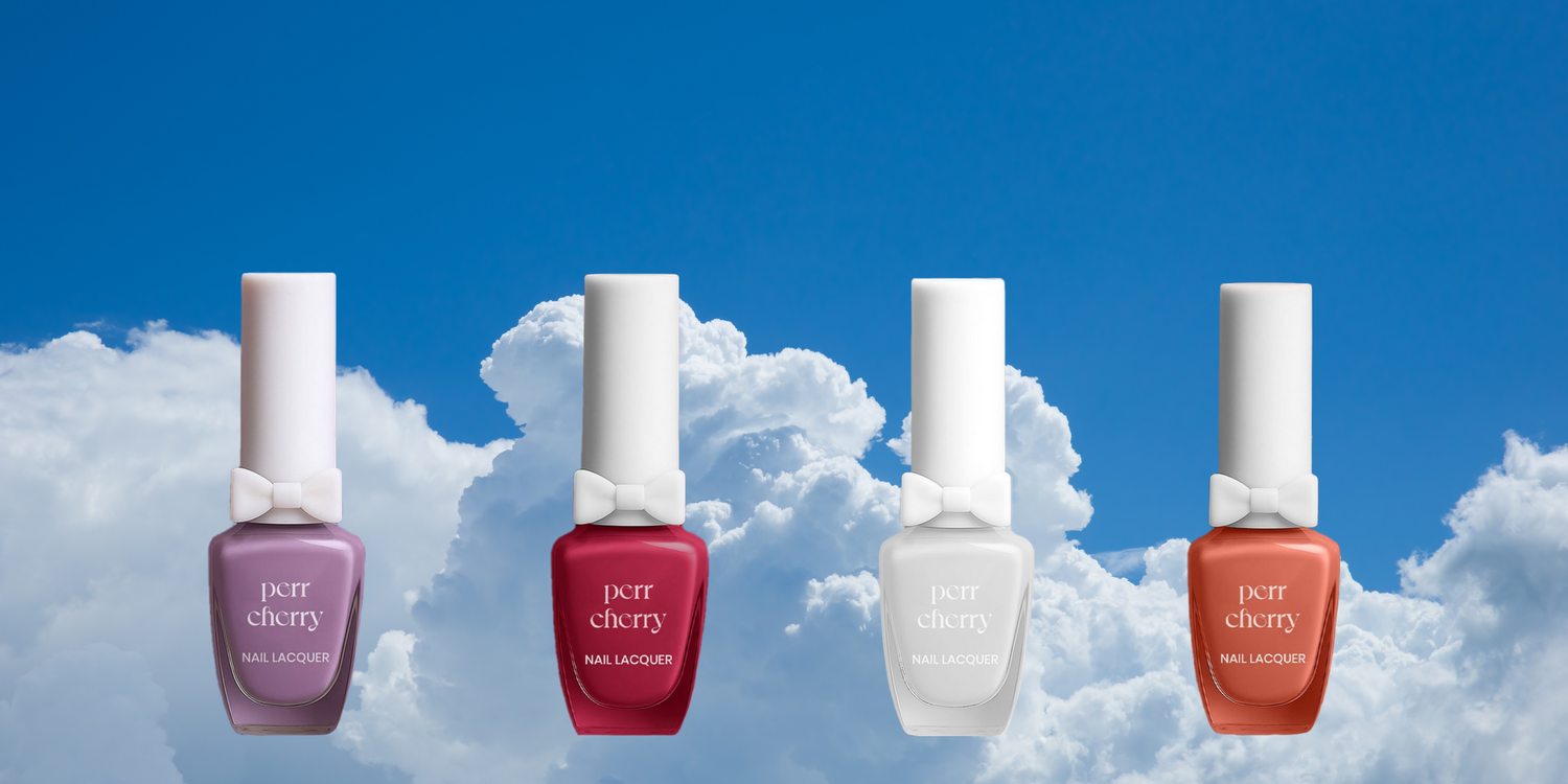 Four bottles of pet cherry nail polish against a blue sky with clouds
